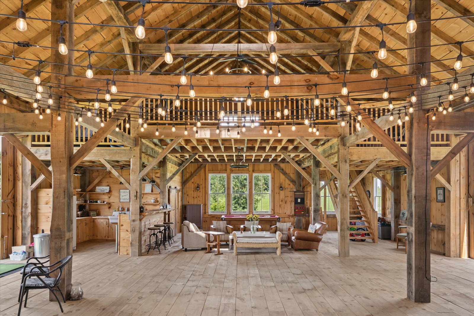 String-lit barn interior with lounge and loft above