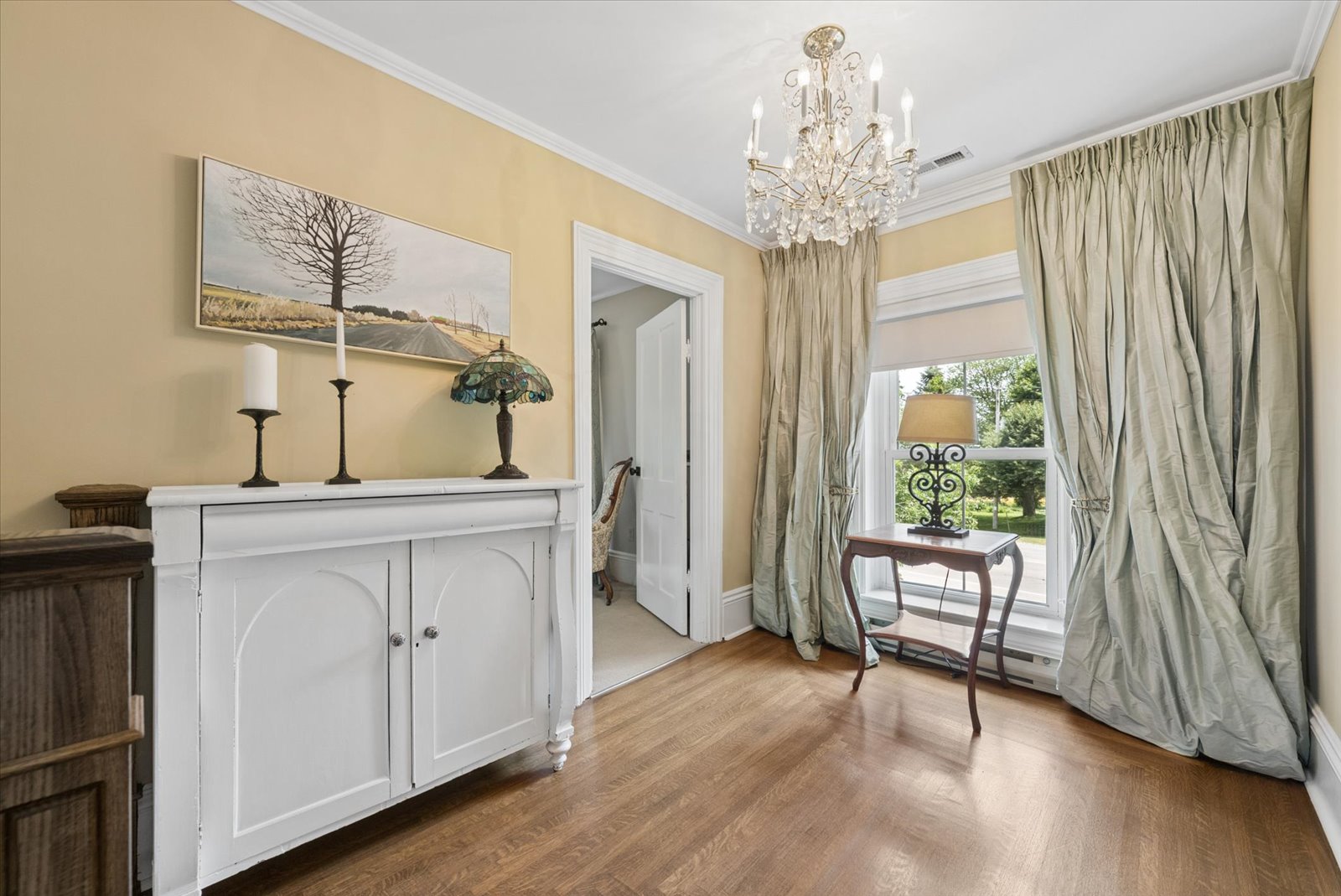 Upper hall sitting area with antique cabinet and chandelier