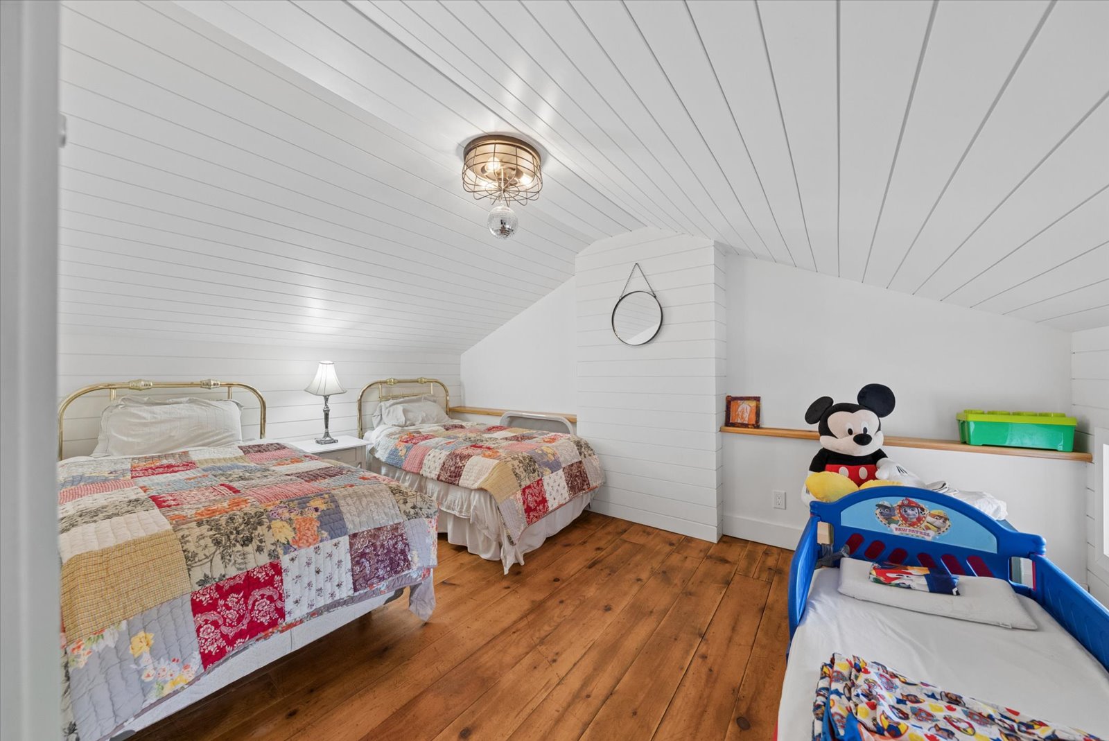 Shiplap bunk room with pine floors and patchwork quilts