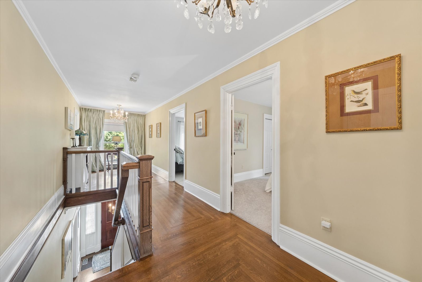 Upper landing with parquet floors and chandelier over the stair