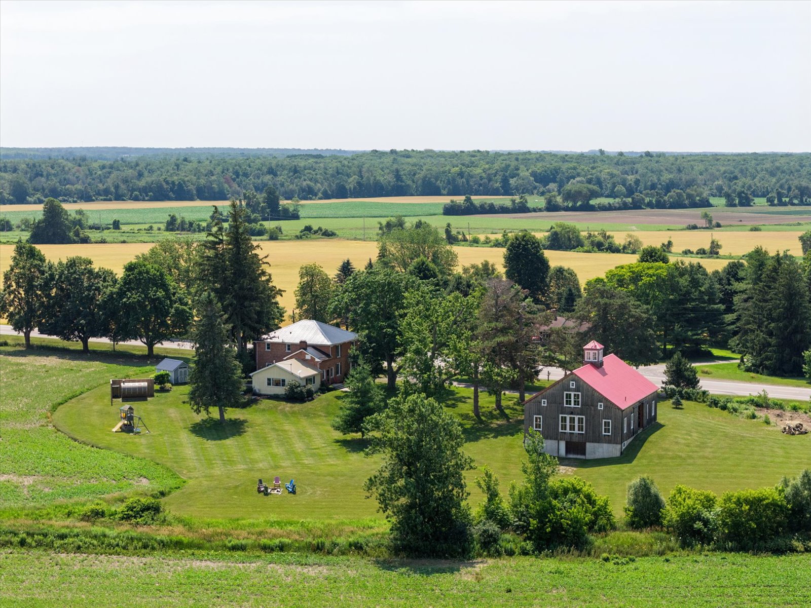 The farmhouse and red-roofed barn set against open county fields