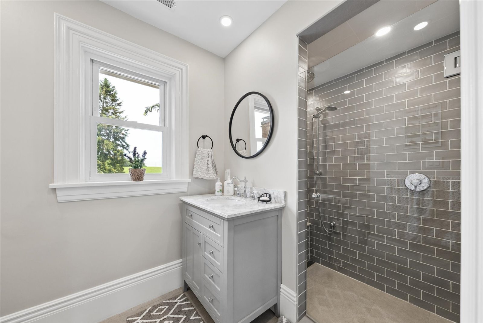 Family bath with marble vanity and tiled walk-in shower
