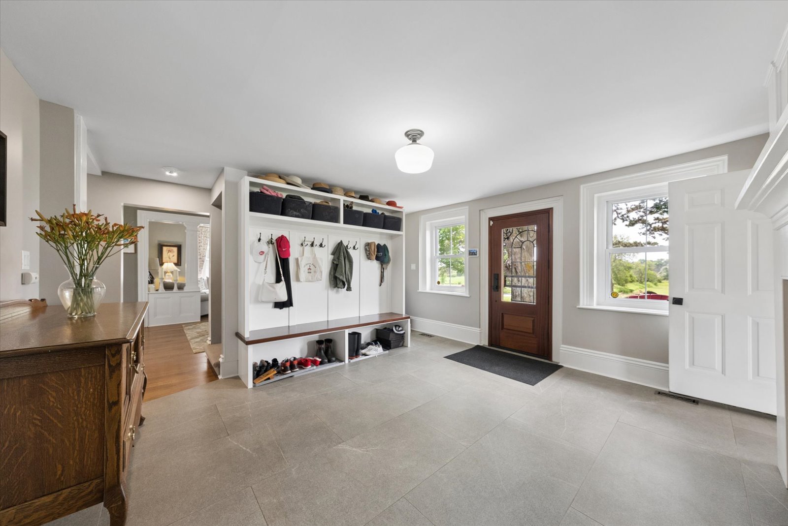 Mudroom entry with built-in bench, hooks and stone tile