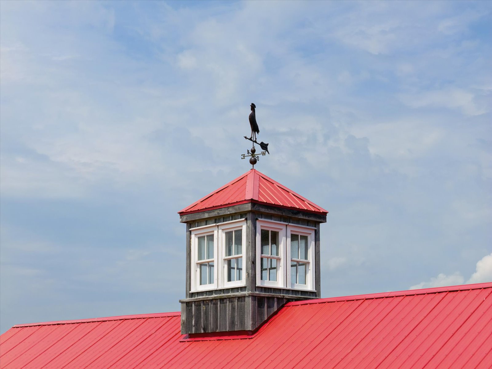 Cupola and rooster weathervane above the red barn roof