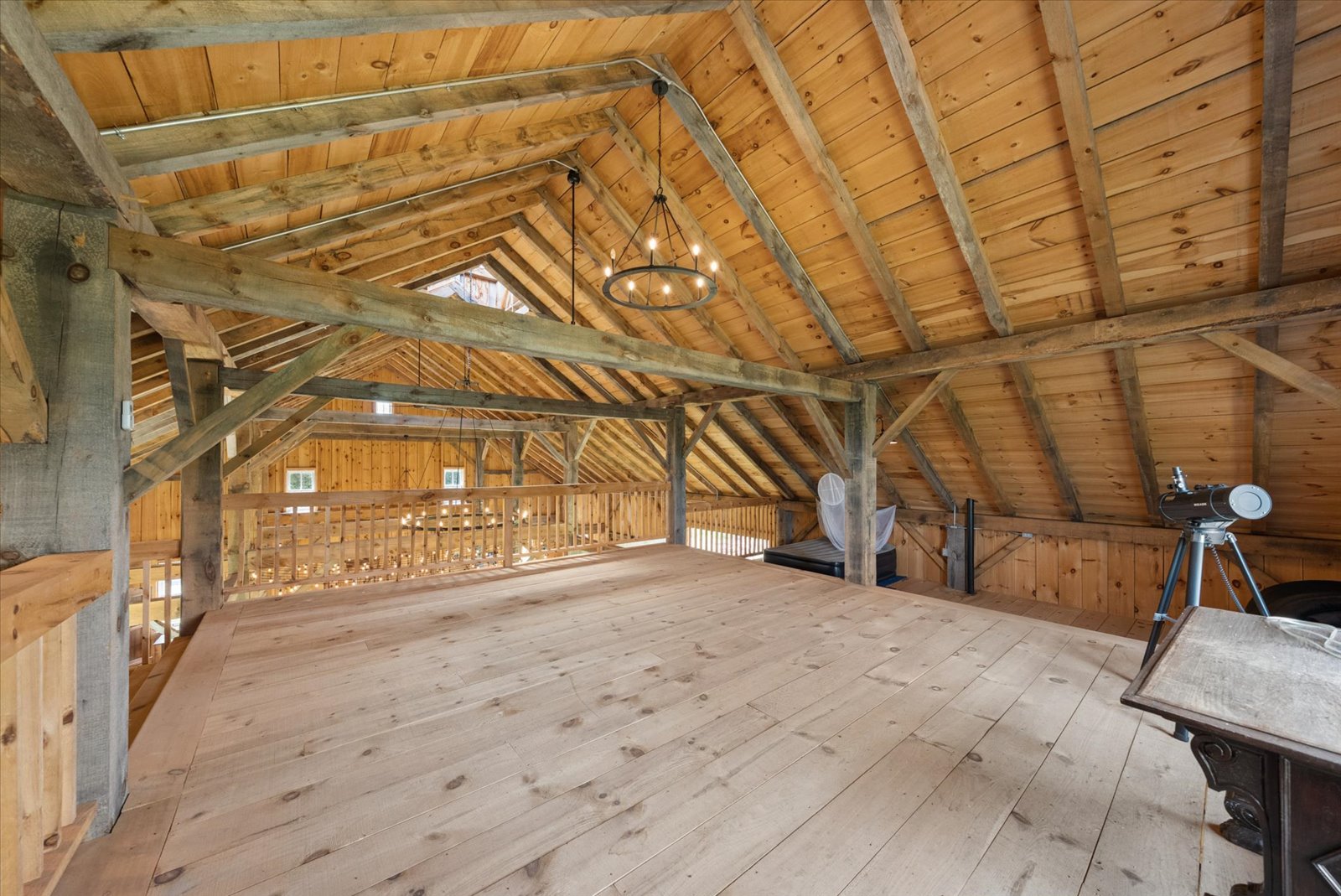 Barn loft with vaulted ceiling and iron ring chandelier