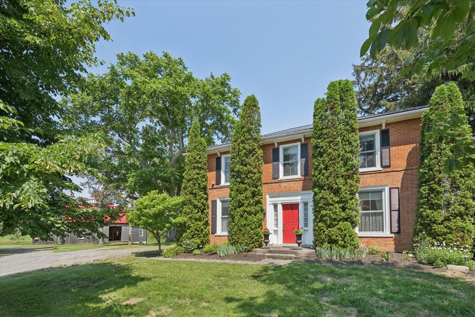 Front elevation with red door and cedar sentries