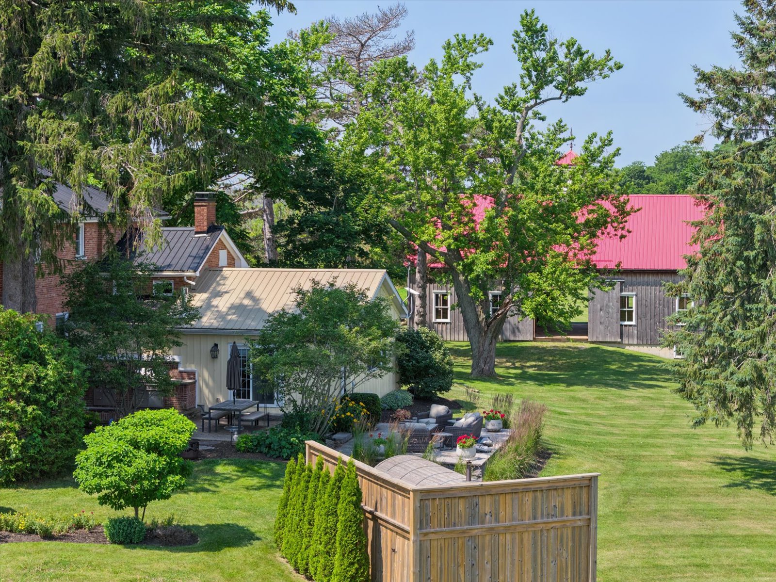 Aerial view over the gardens toward the red-roofed barn